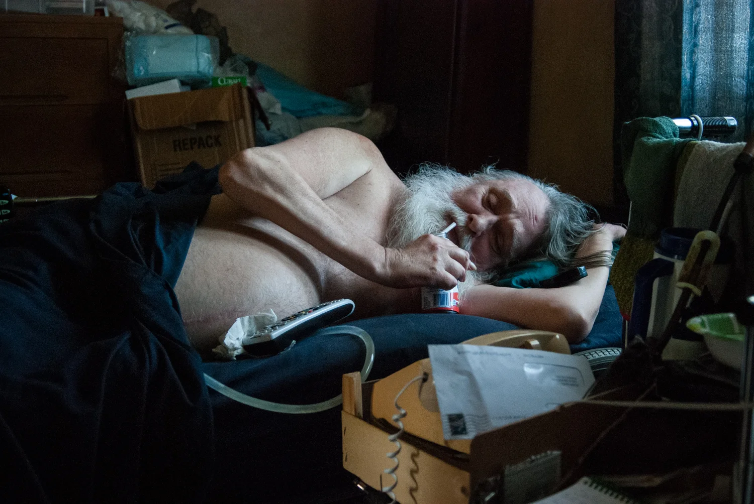 David Helman, 63, drinks cranberry juice at his home in Riverdale, Mich. on Nov. 15, 2015. Helman was injured in a diving accident at 18 and is now mostly confined to his bed. 
