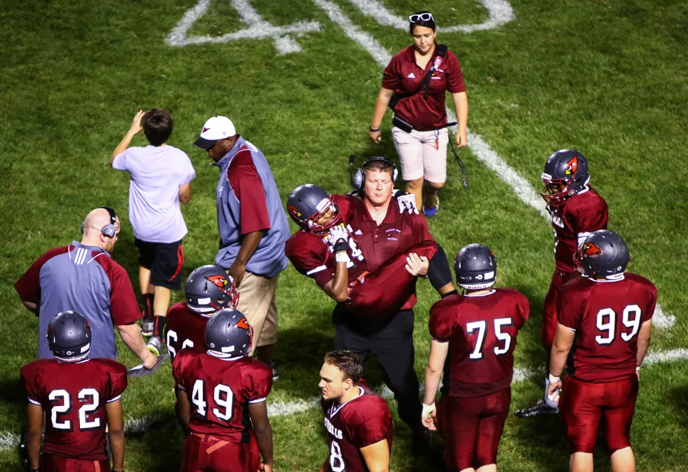 Orchard View High School players look on as their teammate is carried off the field during a game vs. Spring Lake High School on Sept. 18, 2015.