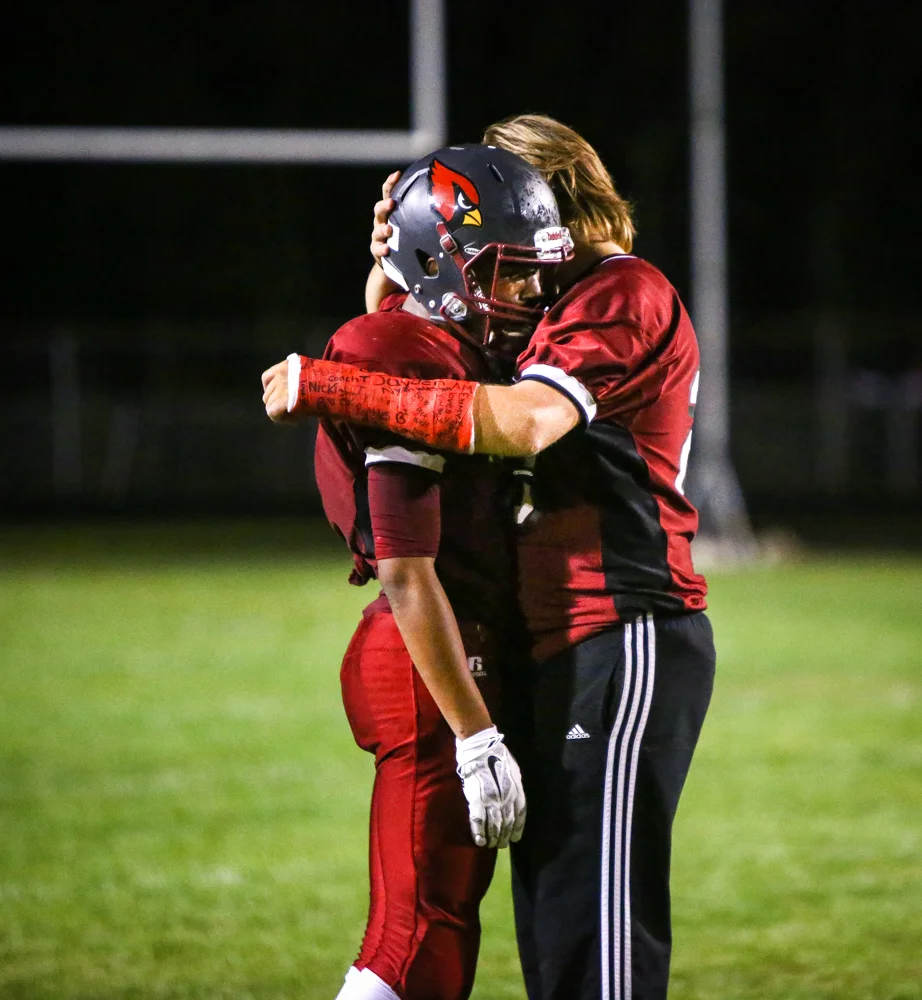 An Orchard View player comforts his teammate after losing to Spring Lake High school on a late touchdown on Sept. 18, 2015 in Muskegon, Mich. 