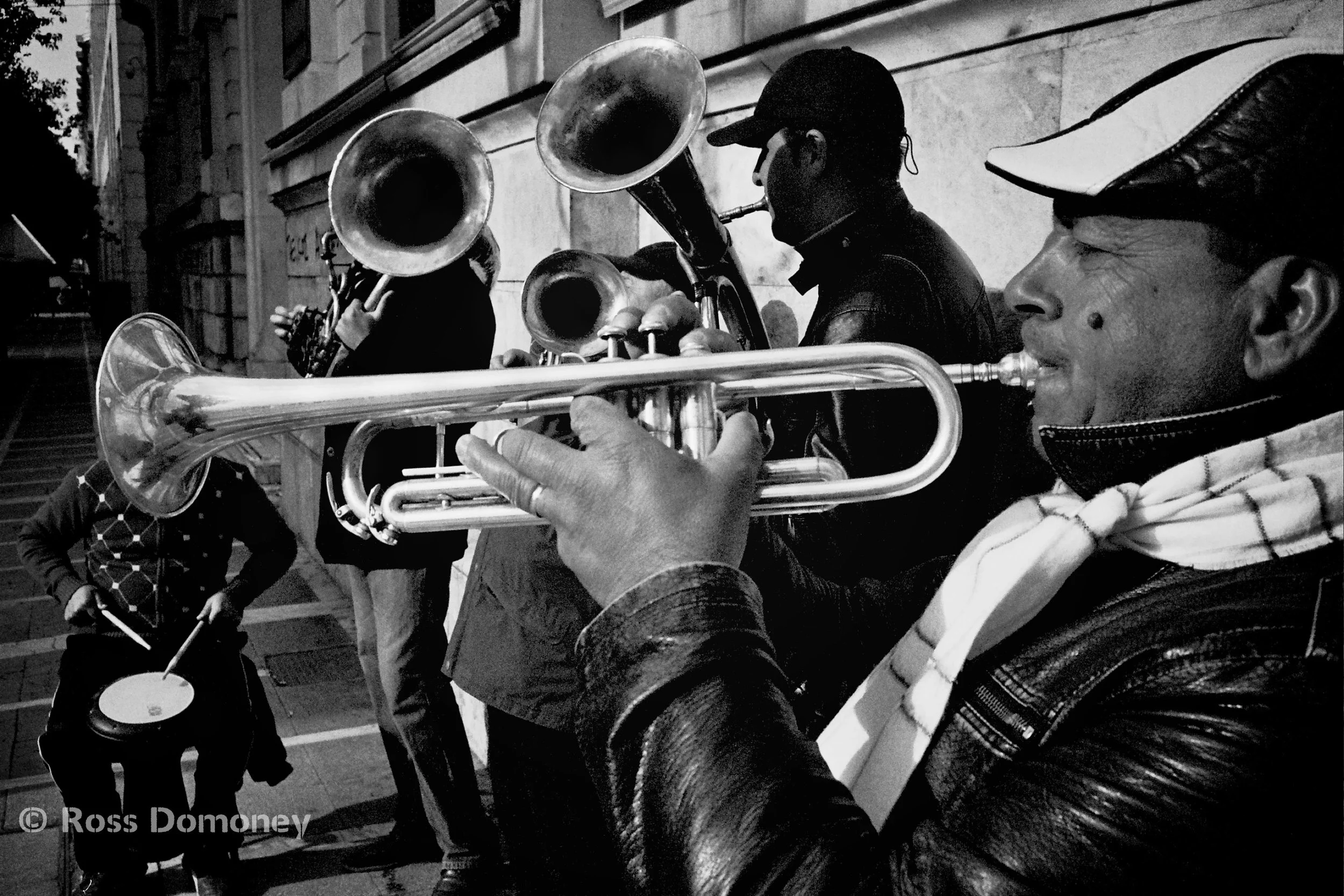 A band plays music as an anti-austerity demo marches past