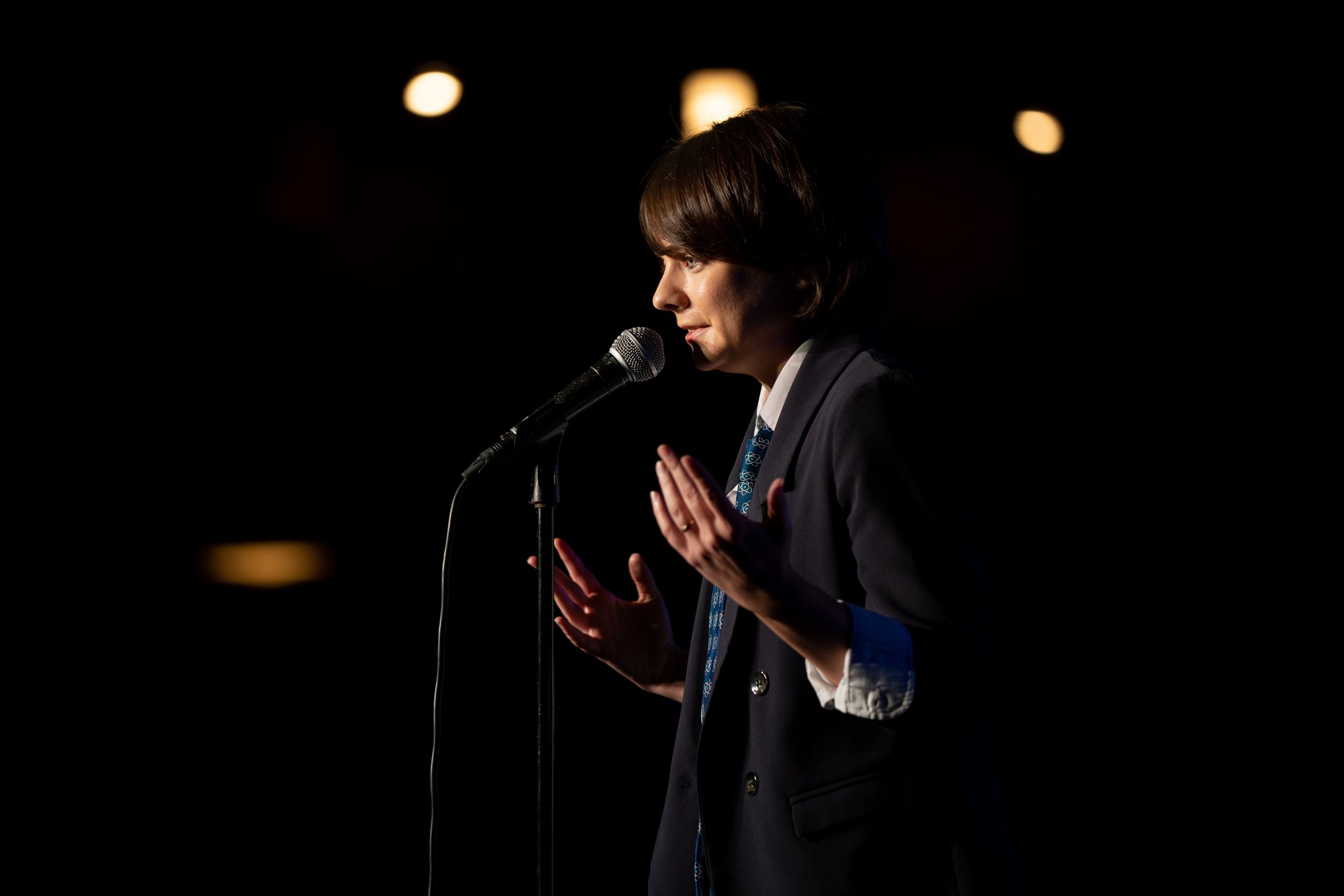  Story Collider’s Executive Director Erin Barker on stage at Proton Prom.  