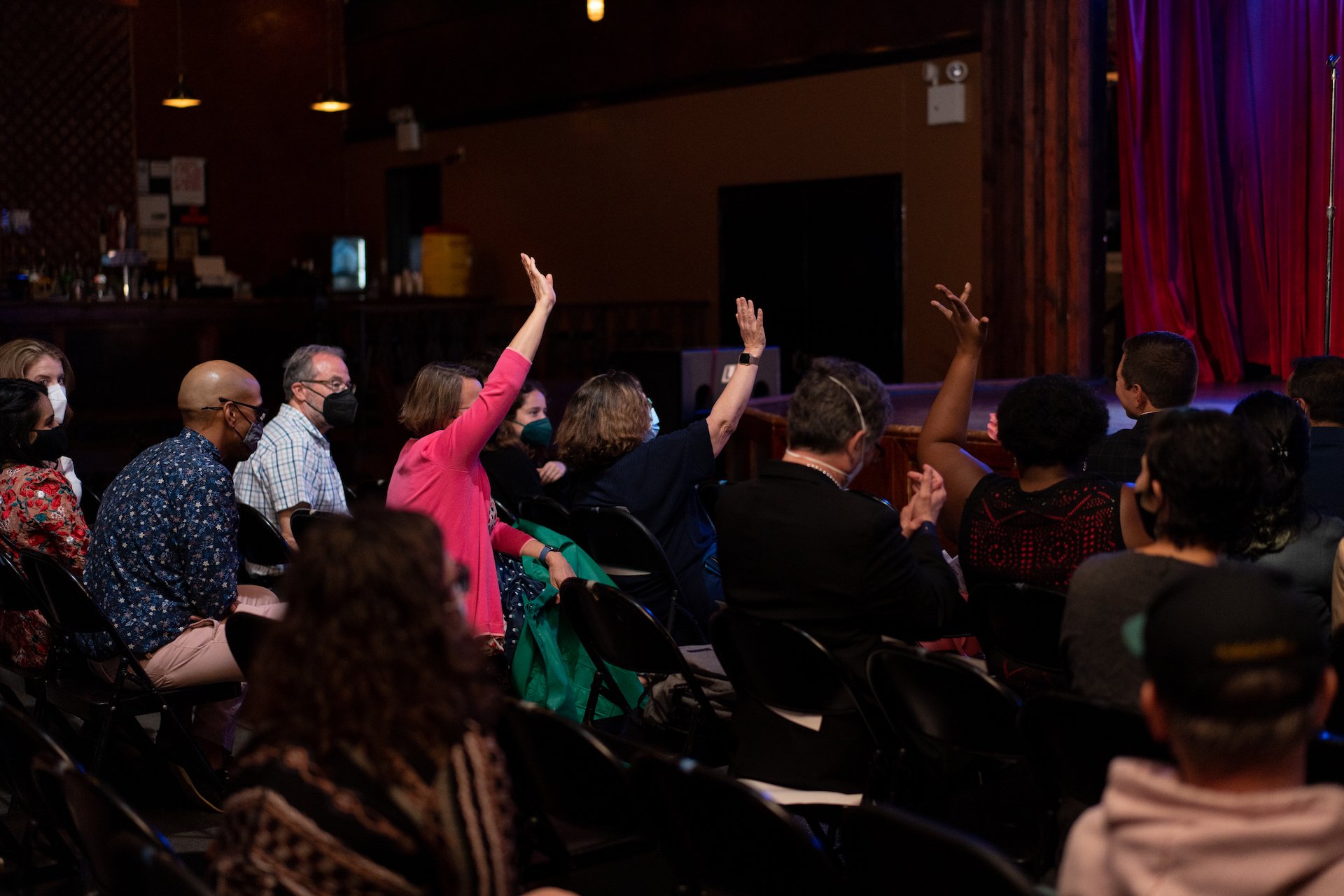  Guests at Proton Prom raise their hands to donate to the Story Collider.  