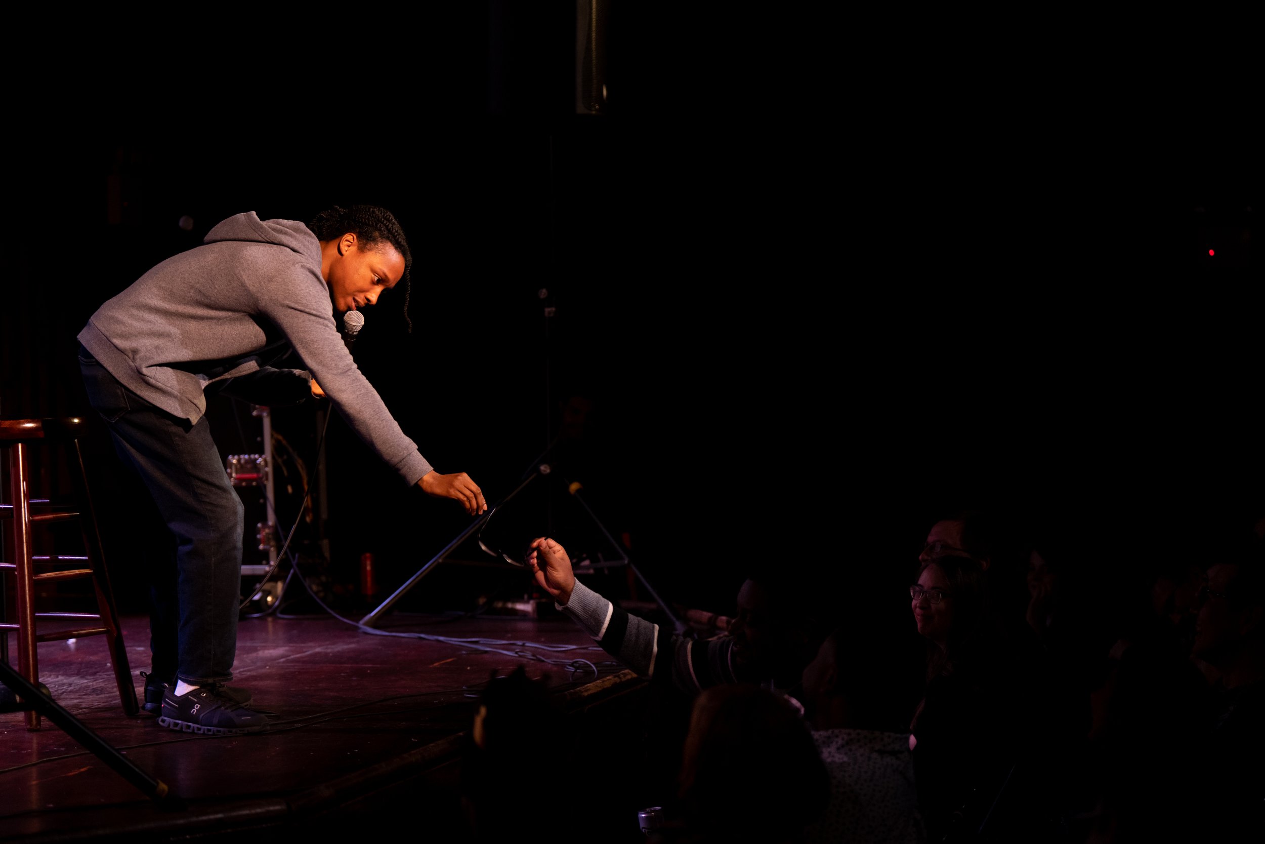  Comedian Josh Johnson reaches for an audience members glasses to try them on.  