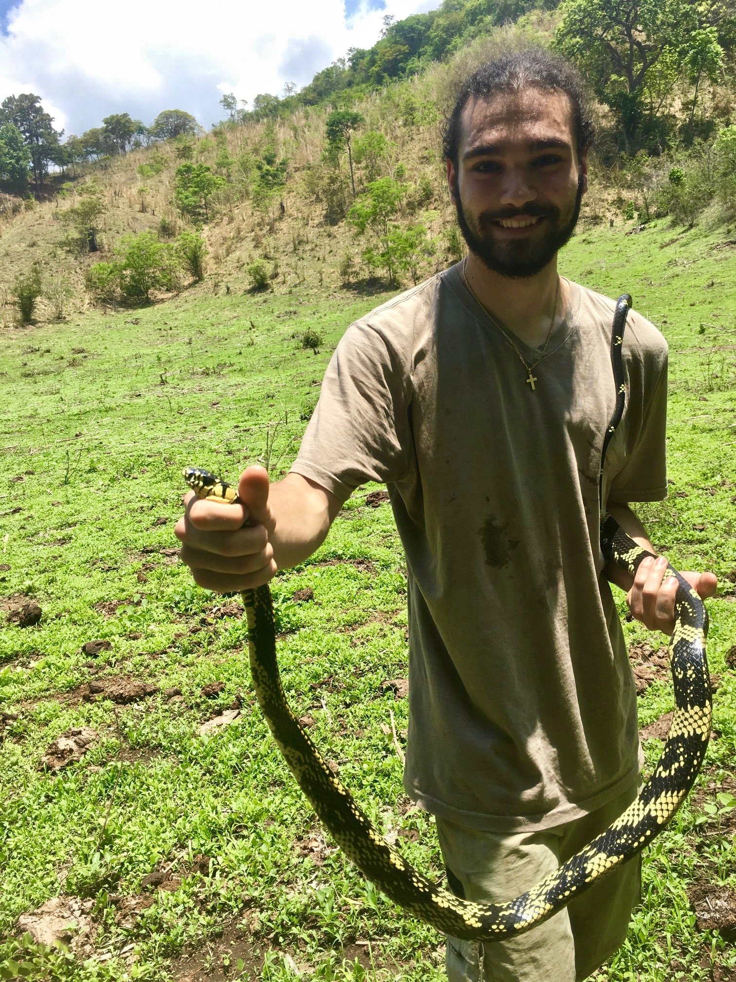    Greg with a hard-earned specimen of a Tiger Rat Snake, Spilotes pullatus, (obtained through a group effort involving machetes, climbing, and a lot of shouting).   