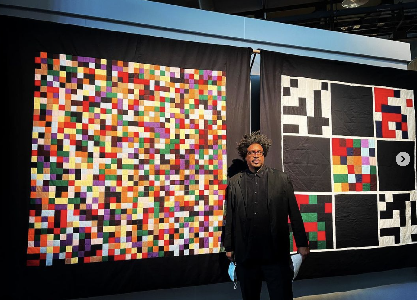  John Sims in front of his quilts. 