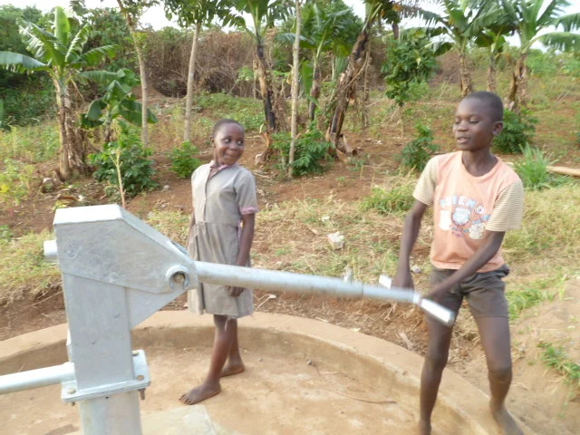 Kids draw water from a repaired well.
