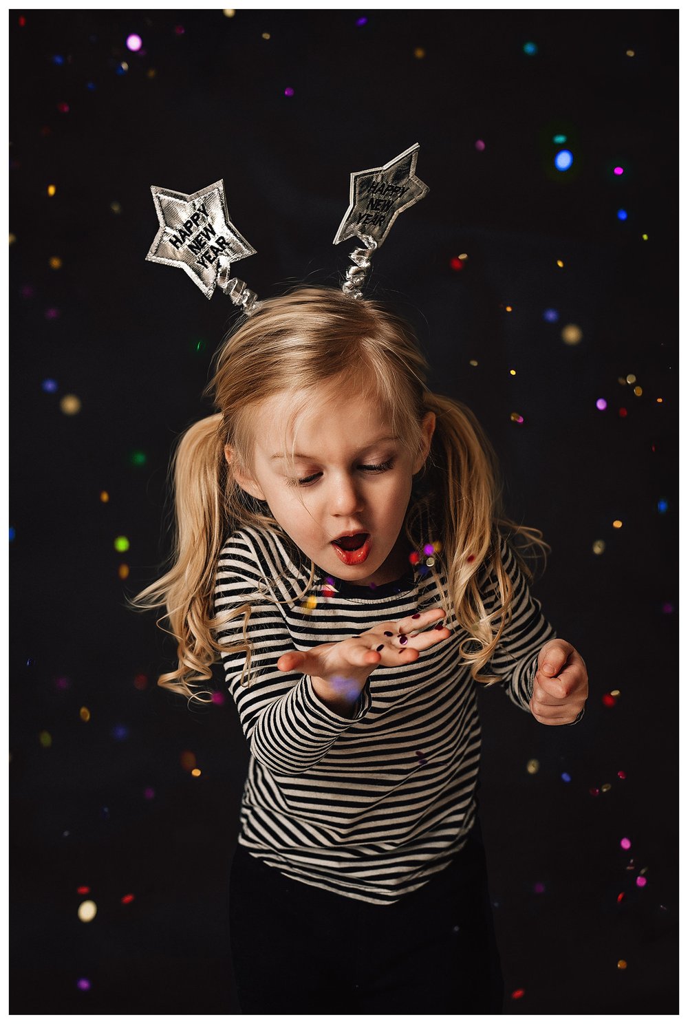 little girl blowing glitter happy new year studio portrait block background happy joyful excited child celebrating