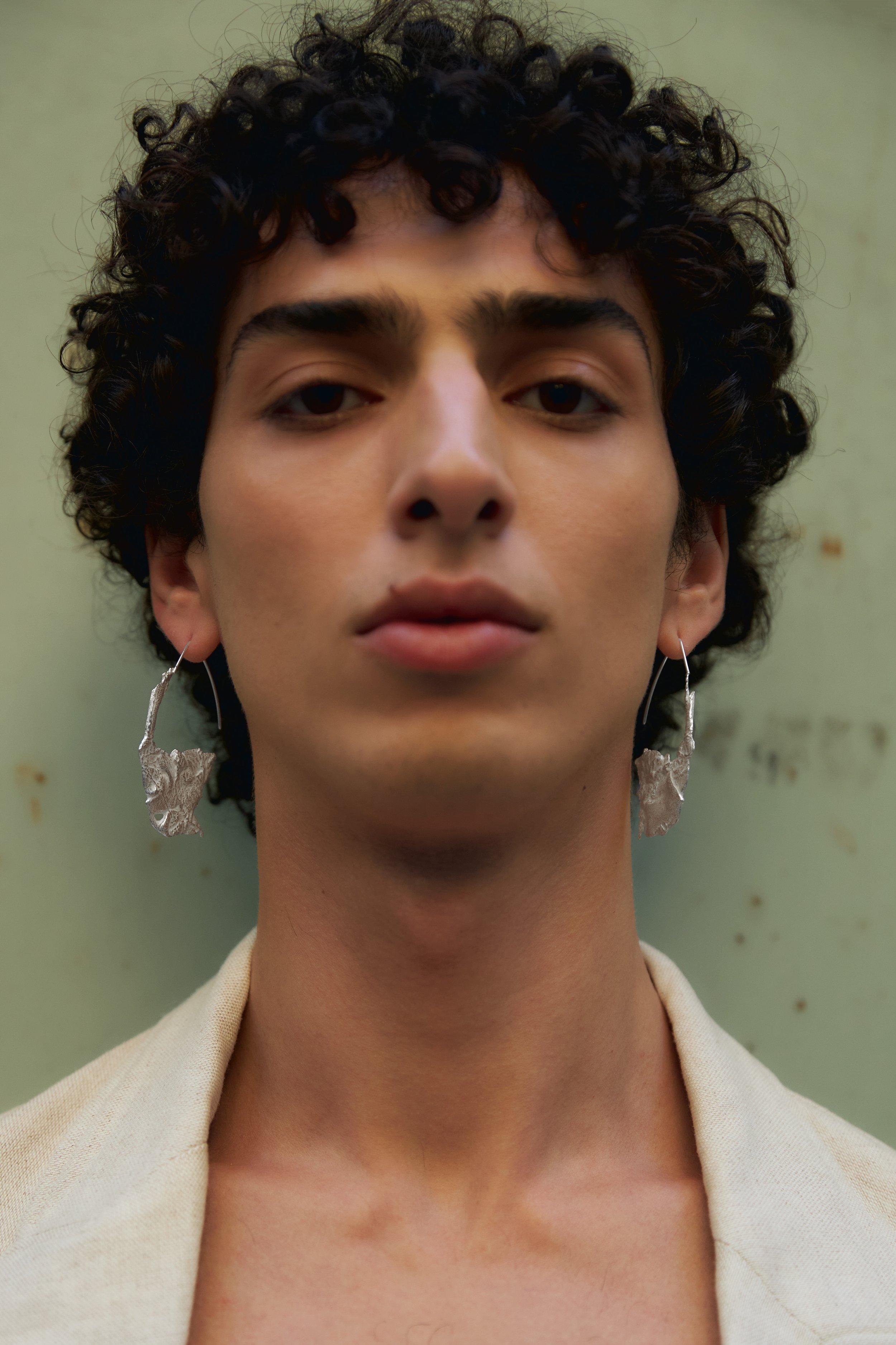 Qaher Harhash wearing BOUND Statement Oval Hoops in gold vermeil of Fairmined silver from GINA MELOSI's sever/ENwound collection
