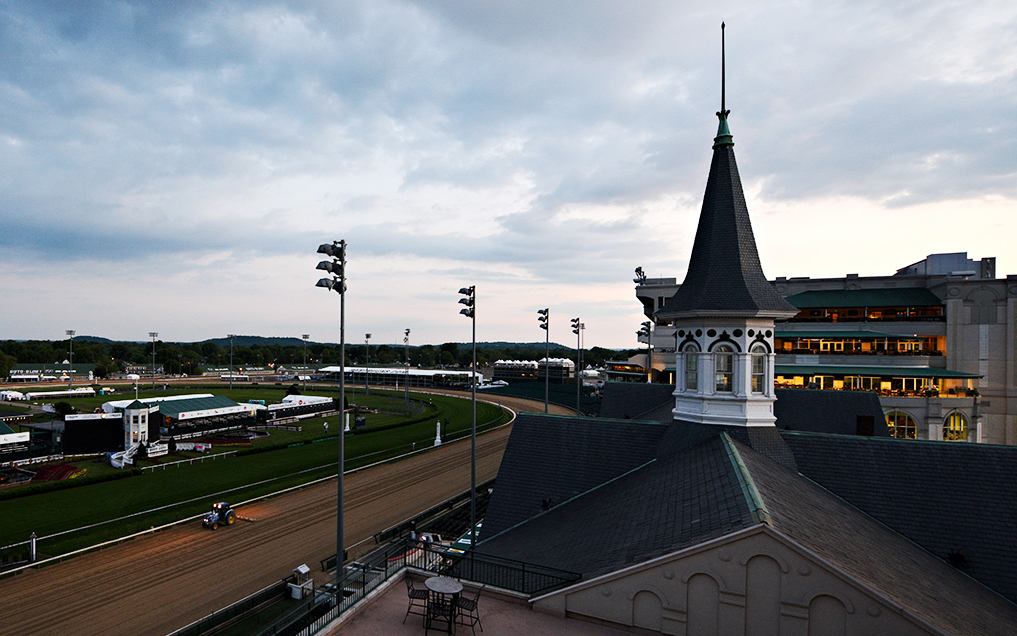 A worker guides a tractor around the track harrowing the surface after races are completed at Churchill Downs on Thurby Day.