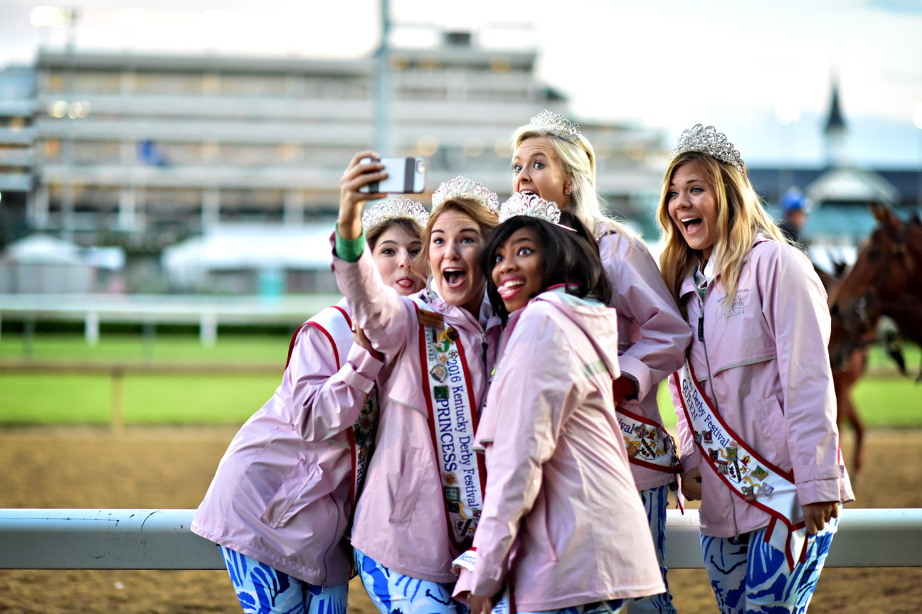 Kentucky Derby Festival princesses pose along the backside at Churchill Downs on Thursday. Festival princess Adrienne Poole, standing middle back, says, "Watching the sunrise this morning along the track at Churchill Downs was icing on the cake and really an experience I'll never forget, so we had to take a selfie."