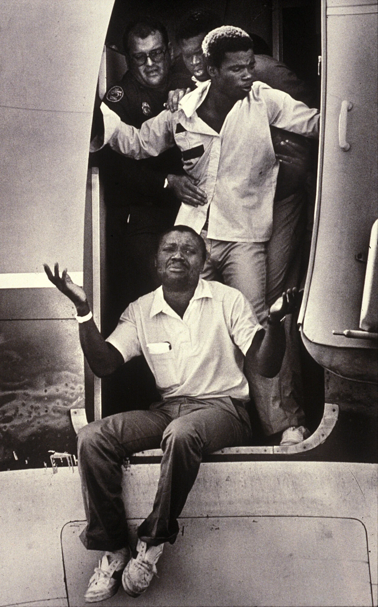  Haitian Refugees fighting deportation, on the runway as they are about to depart Miami International Airport.   