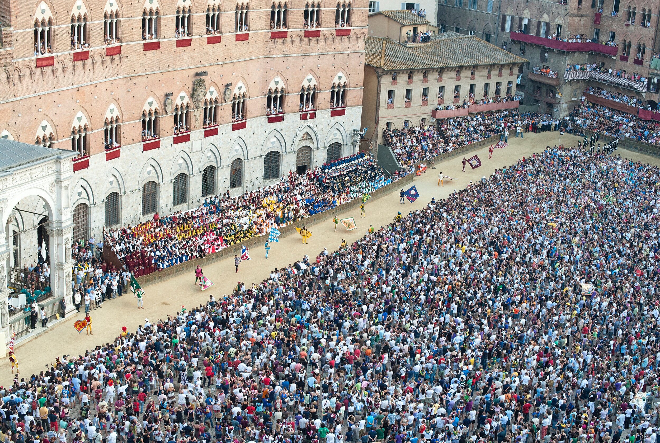 Twice a year, 10 colorfully costumed horses and riders, representing 10 of Sienna’s 17 contrade, race around the medieval Piazza del Campo three times. It’s intense, physical, and always full bore. Before the racing the Corteo Storico- a post parad