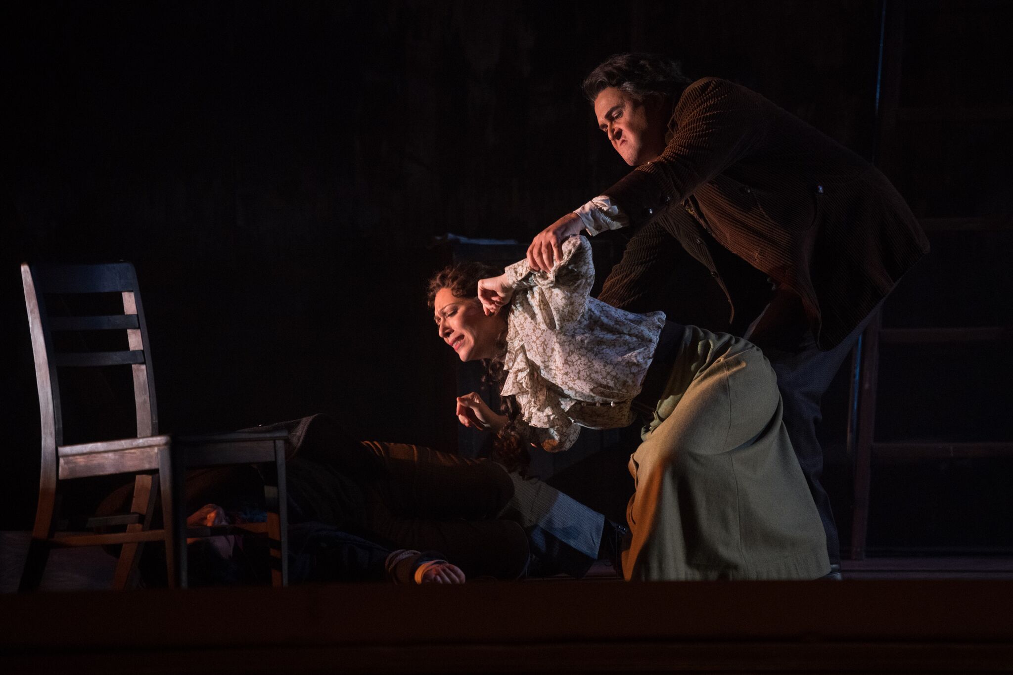 Michele (Grant Youngblood) forces Giorgetta (Eleni Calenos) to look at Luigi's corpse (Matthew Vickers). Photos by Moonloop Photography; courtesy of OperaDelaware.