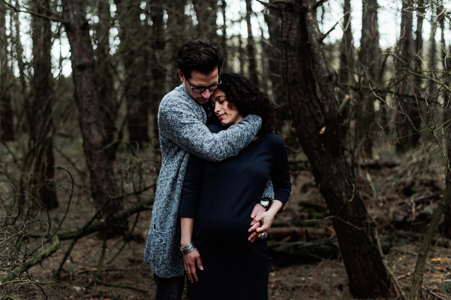 Close up of couple standing in forrest girl pregnant