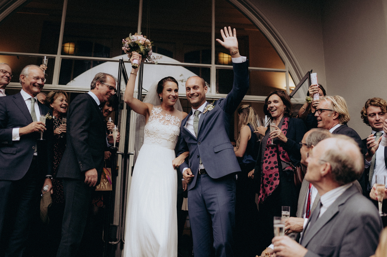 Bride and groom leaving Keizersgracht Kerk Amsterdam while smiling