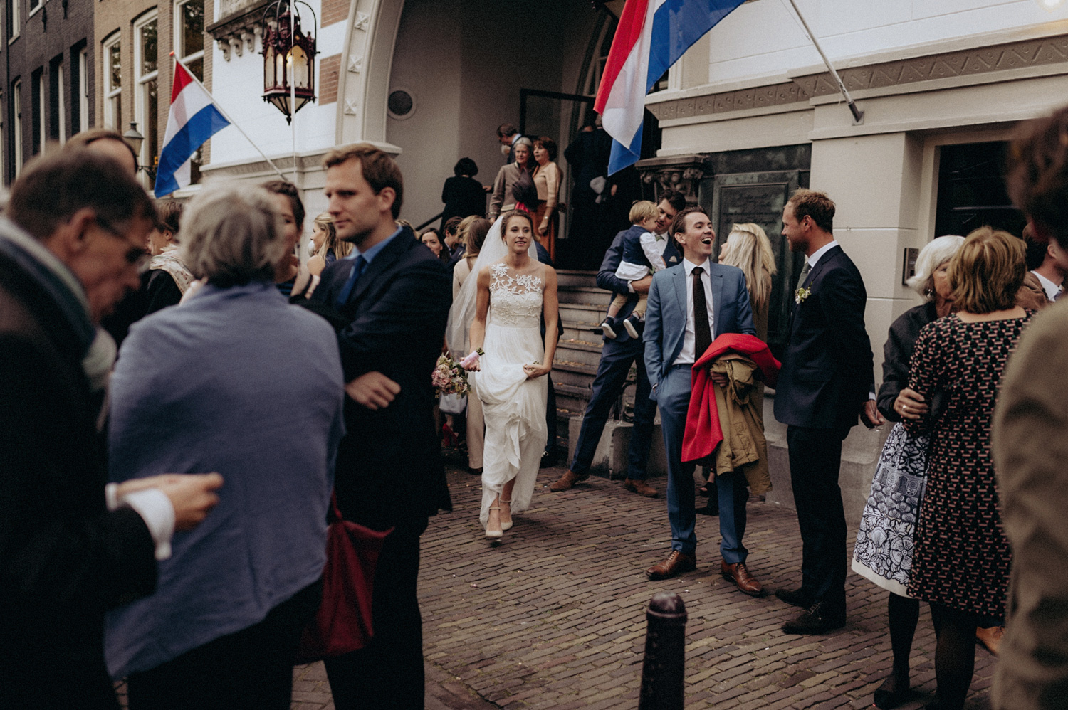 Wedding couple leaving Keizersgracht Kerk Amsterdam with dutch flags