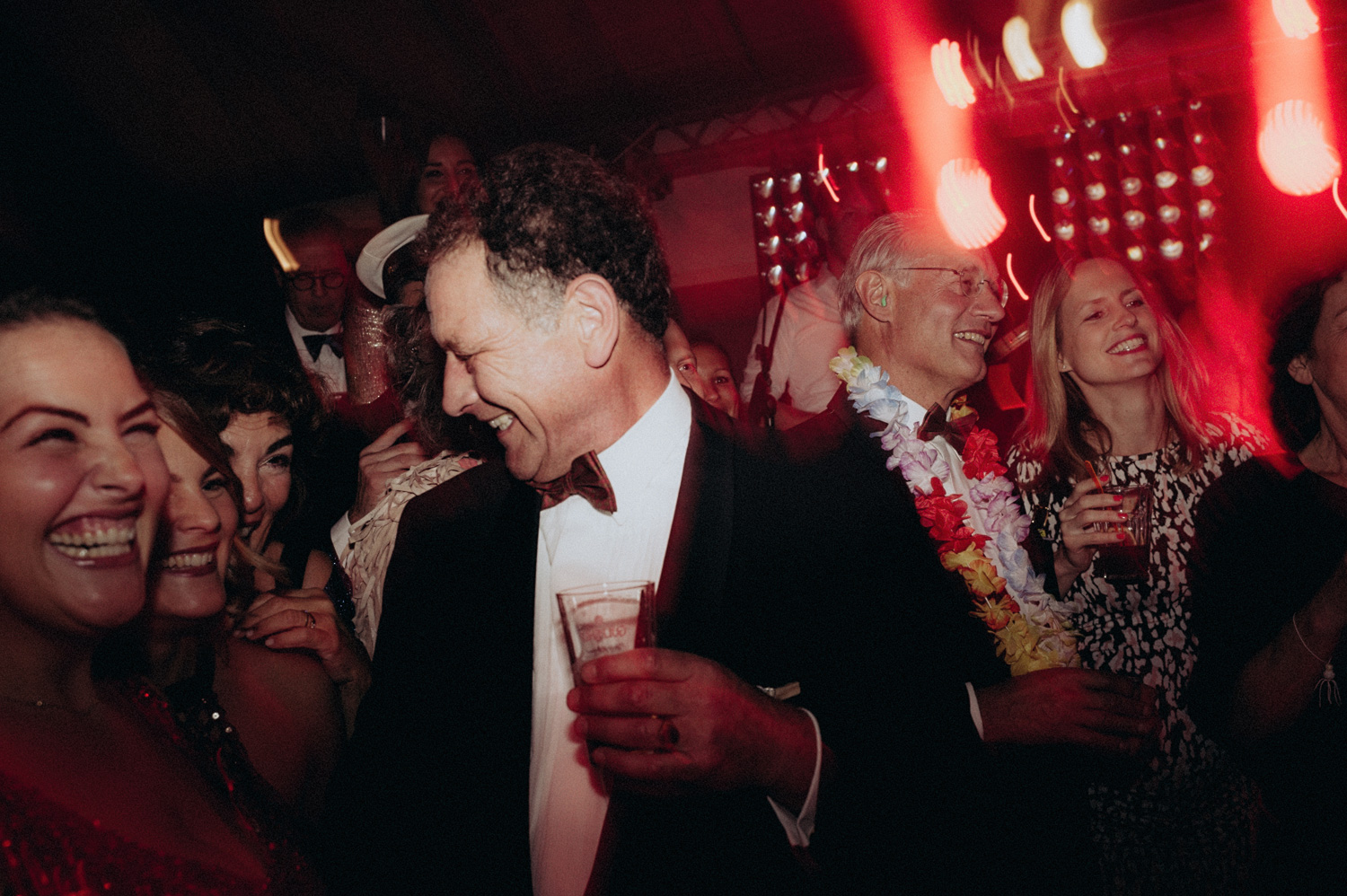 People smiling while dancing and drinking at party, Rijk van de Keizer