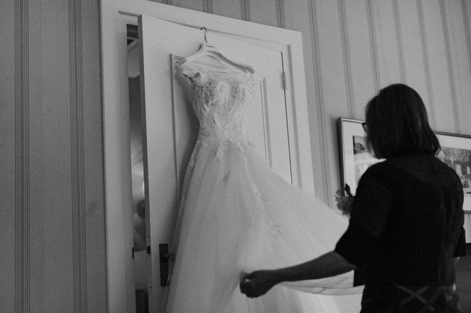 Mom of bride putting dress on door