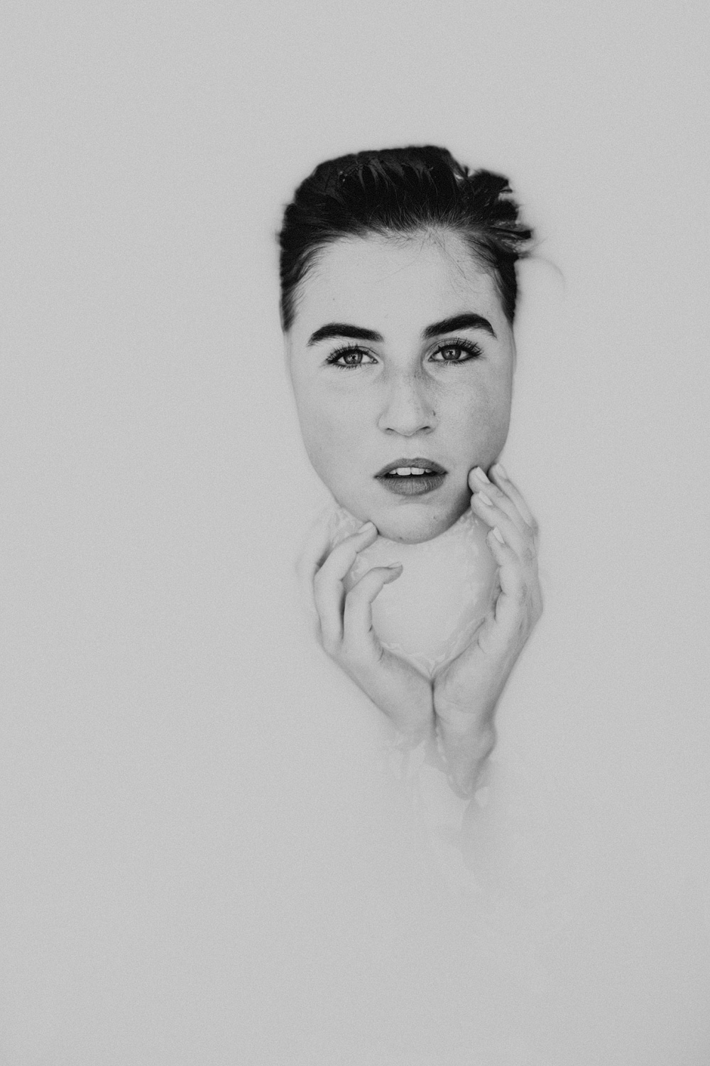 face portrait in bathtub filled with milk