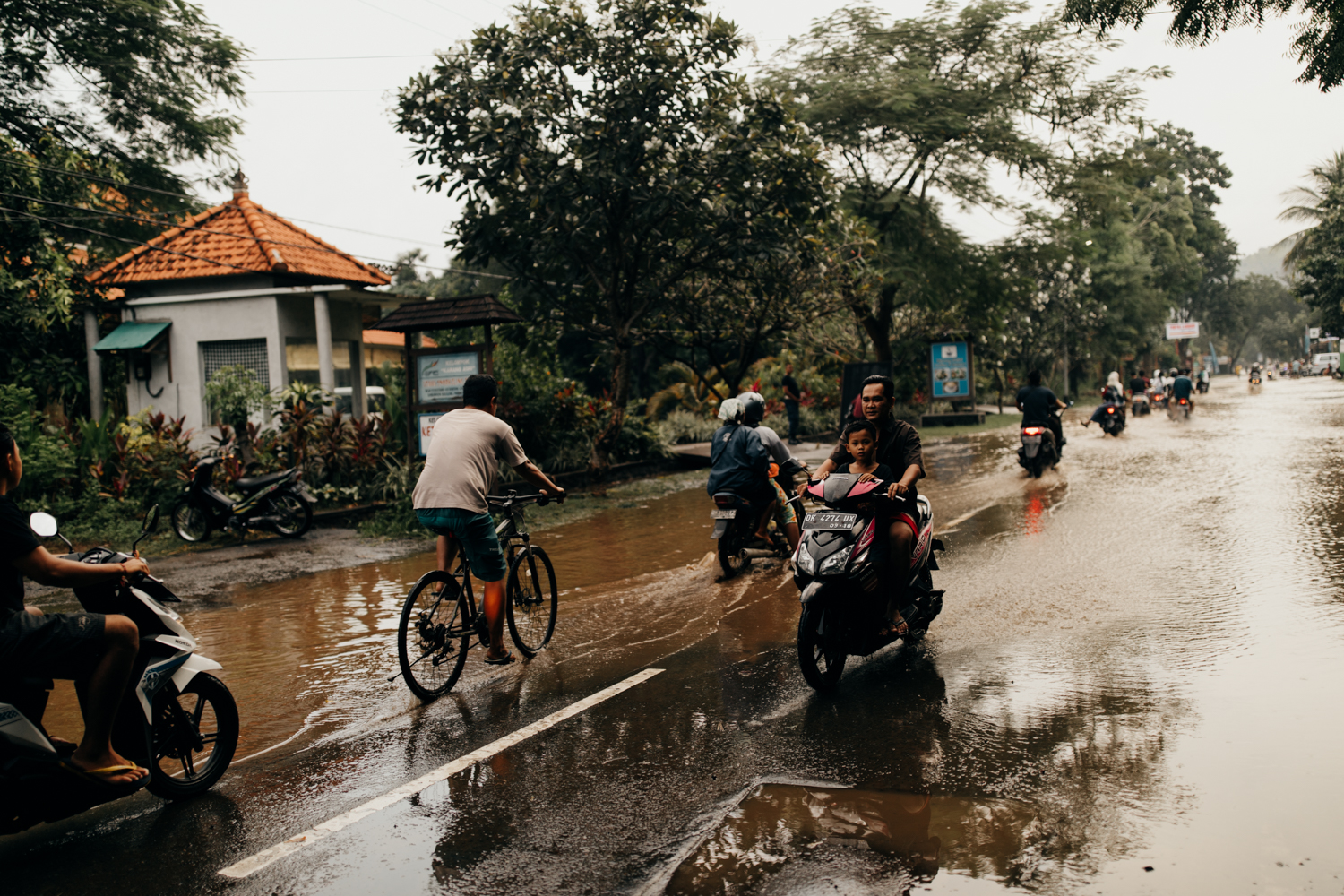 Scooters driving through rain in Bali, Indonesia