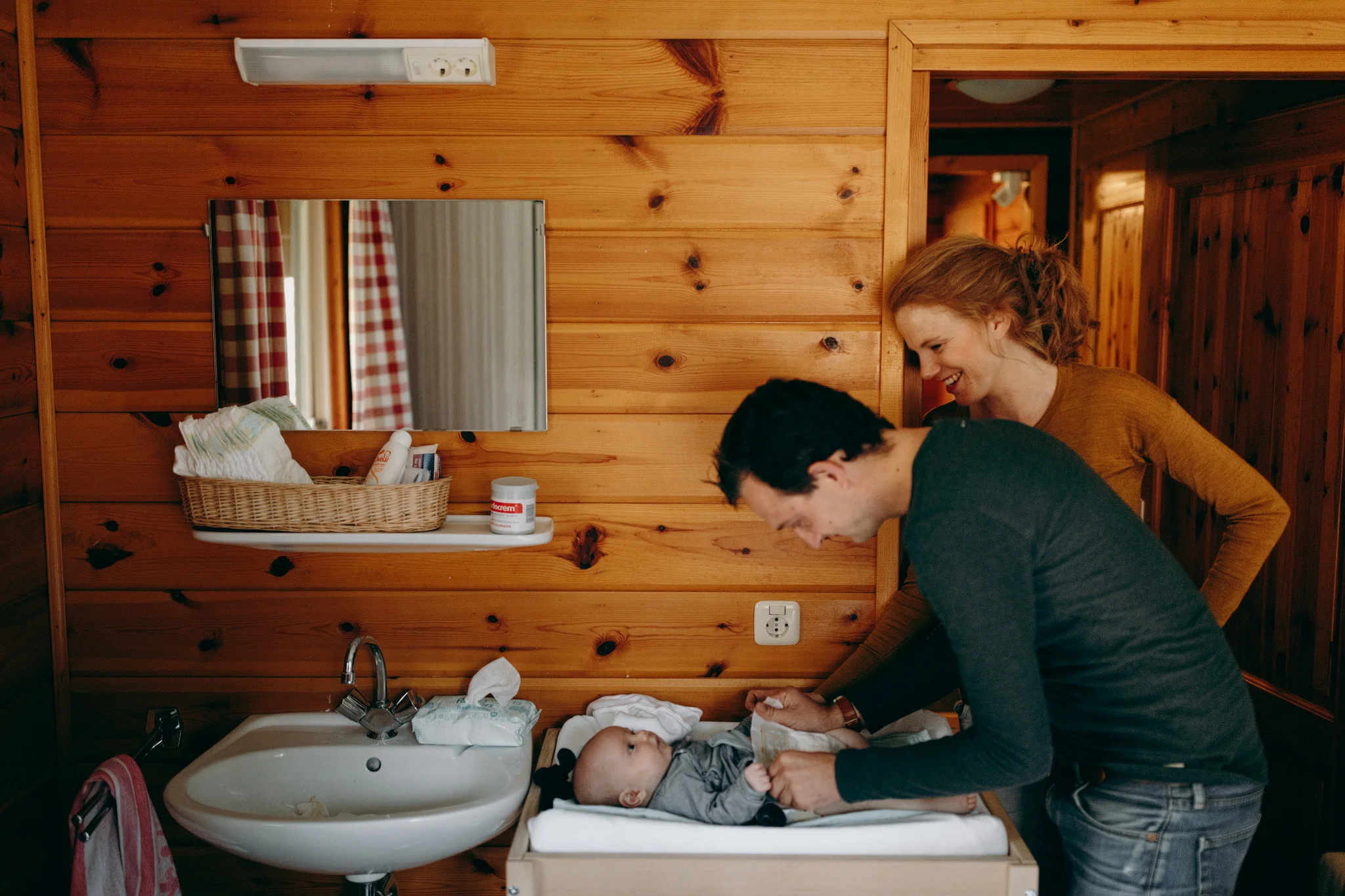 Father and mother watching baby on commode