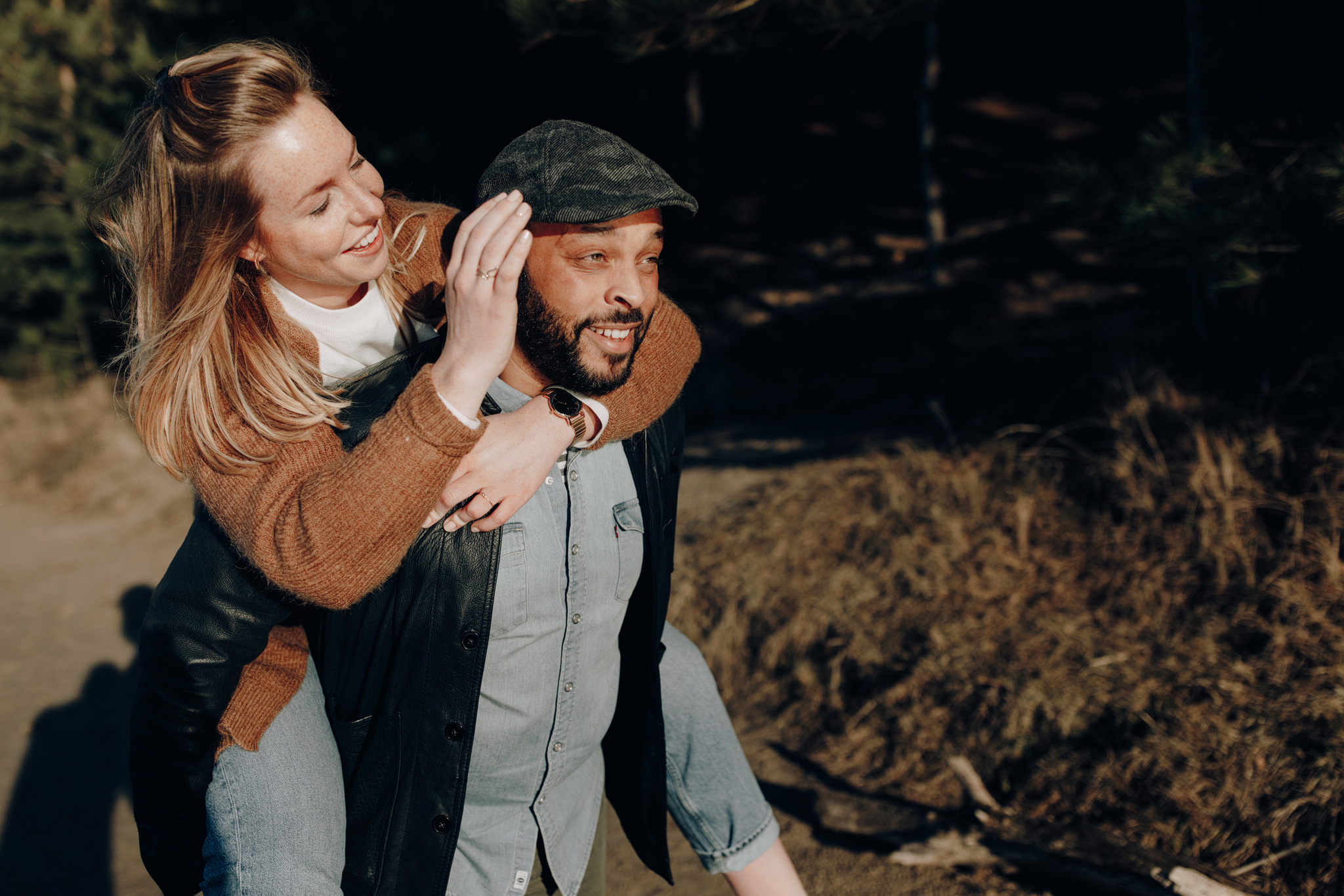 Girl jumping on the back of boyfriend while smiling