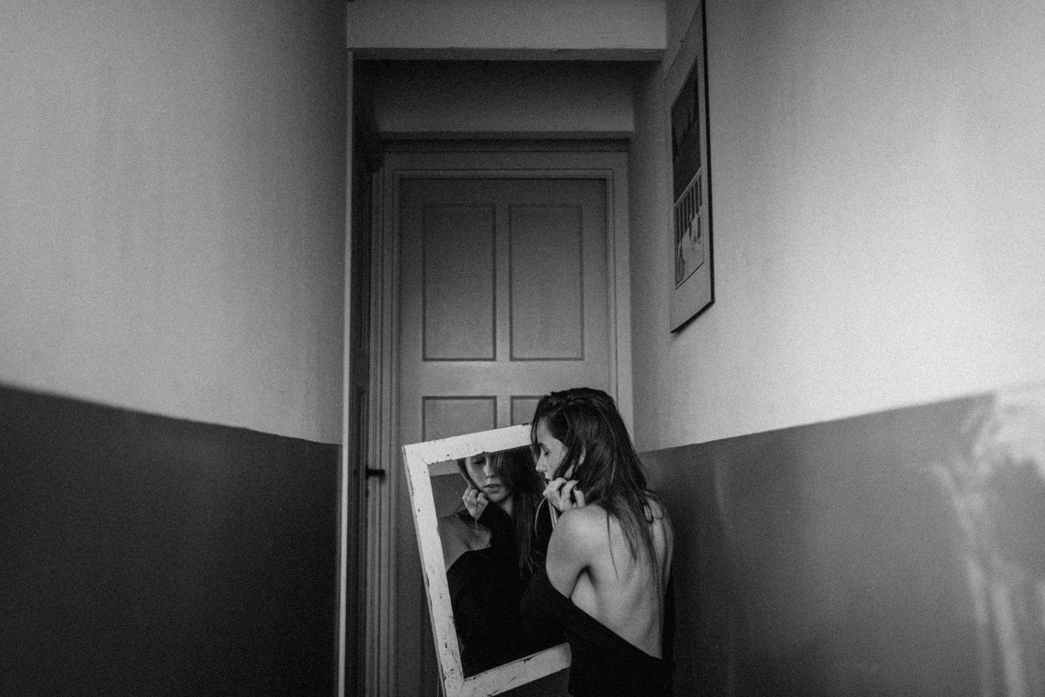 Girl holding mirror in front of door