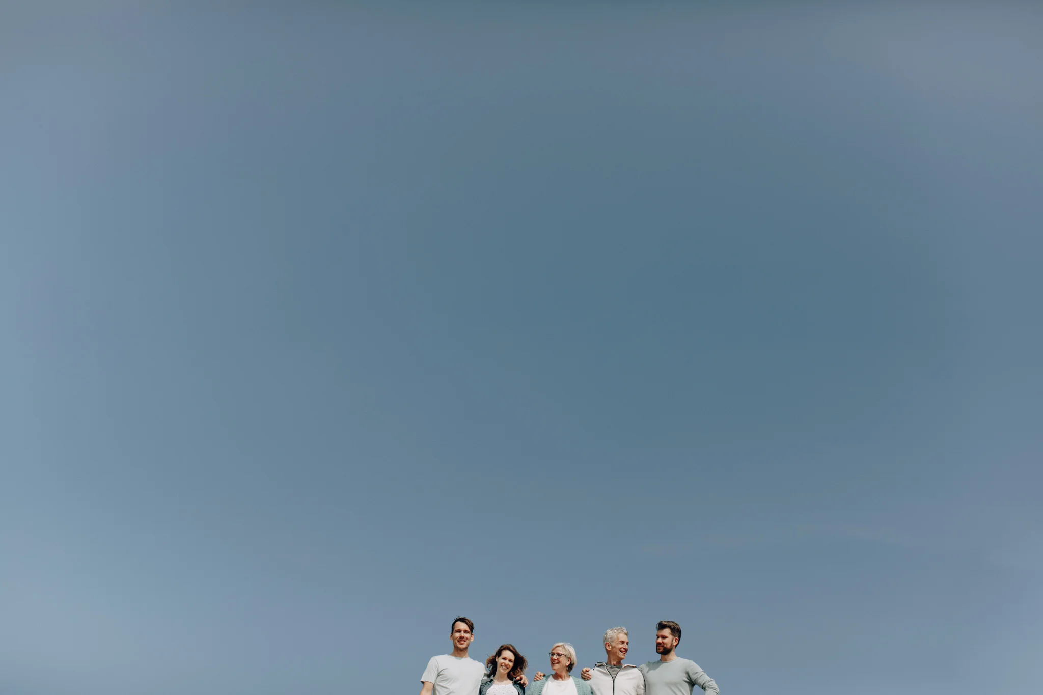 Blue sky with family posing for a picture