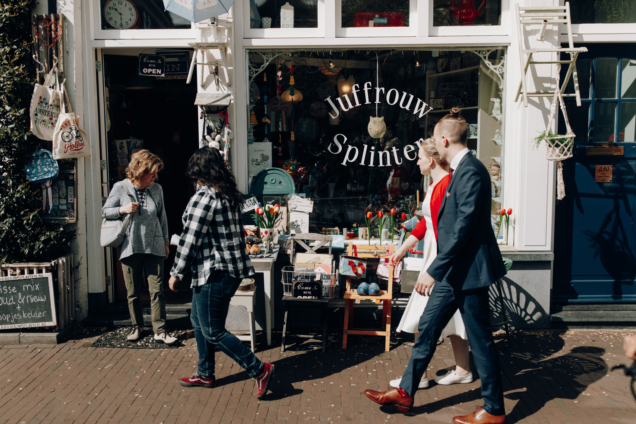 Elopement couple walking past shops in Amsterdam