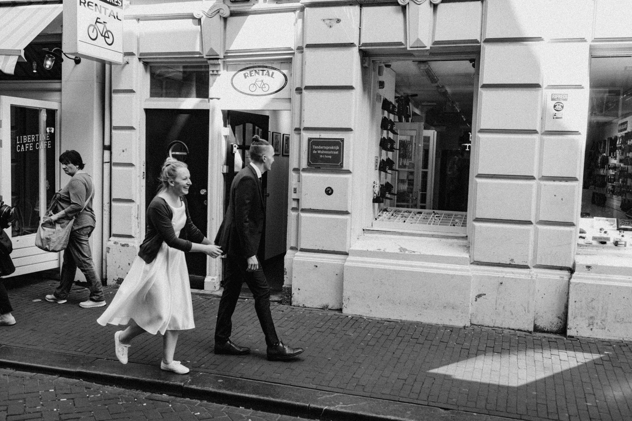 Elopement couple walking past bike rental shop in Amsterdam