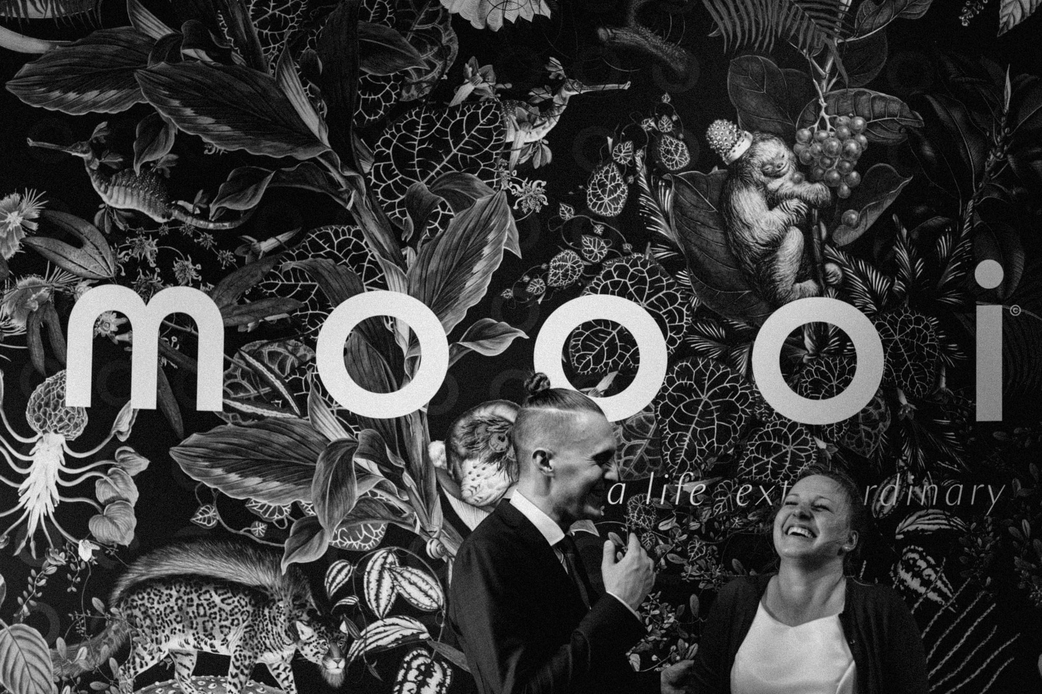 Elopement couple standing in front of big poster that says moooi