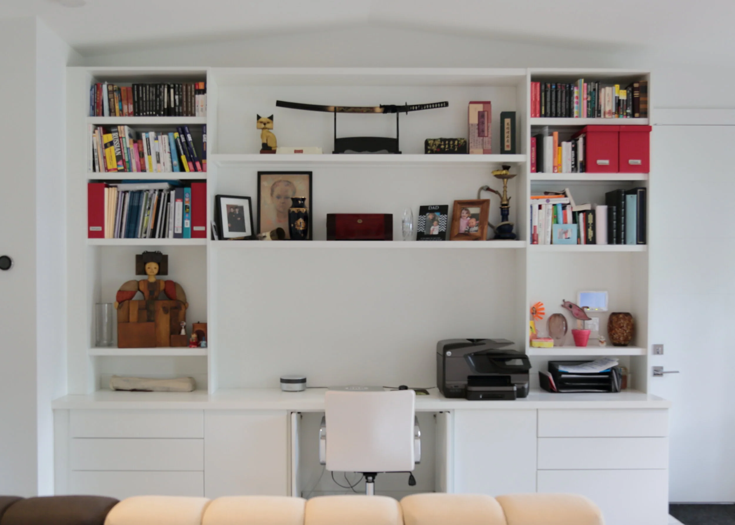 Built in white workstation with bookshelves and pocket doors beside the desk opening