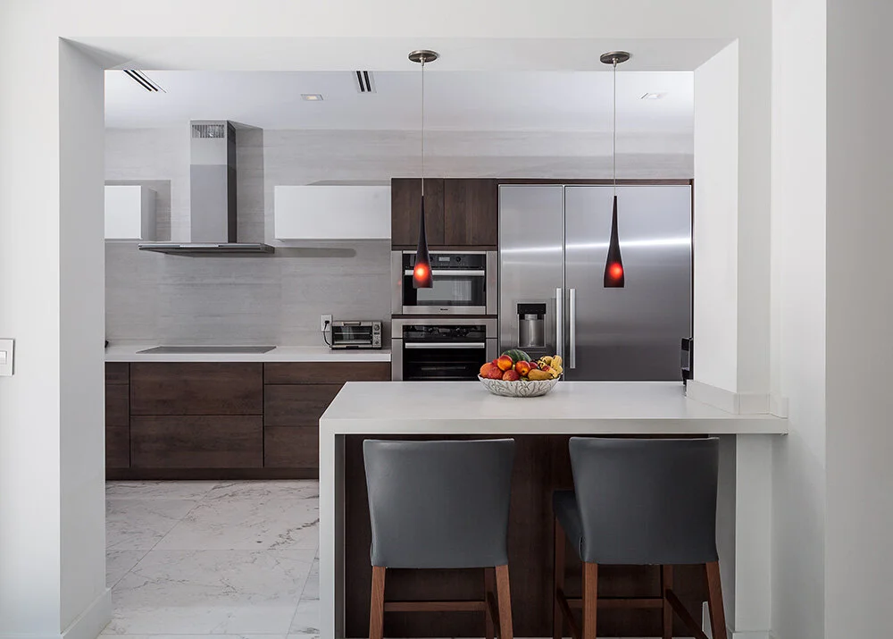 Front view of the completed modern kitchen, with a peninsula and seating for two
