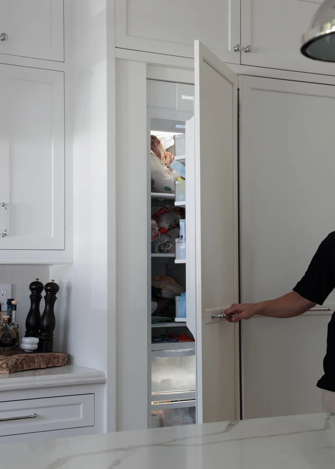 An open integrated freezer showing the structural column concealed by its extended cabinet panel