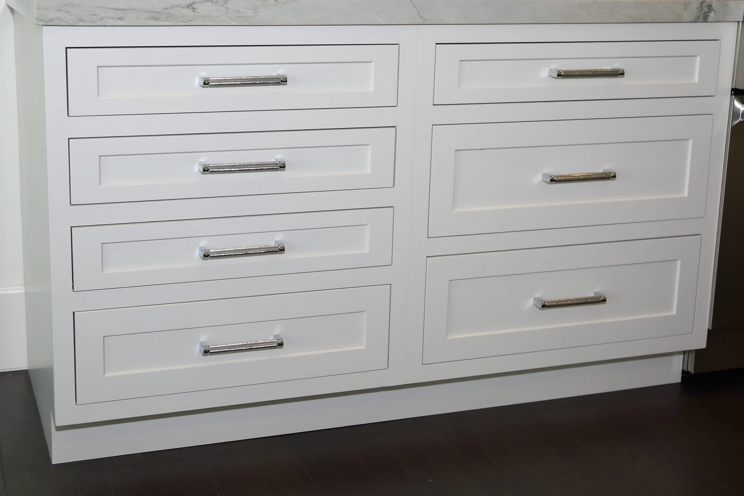 White drawer cabinetry with linear metal pulls