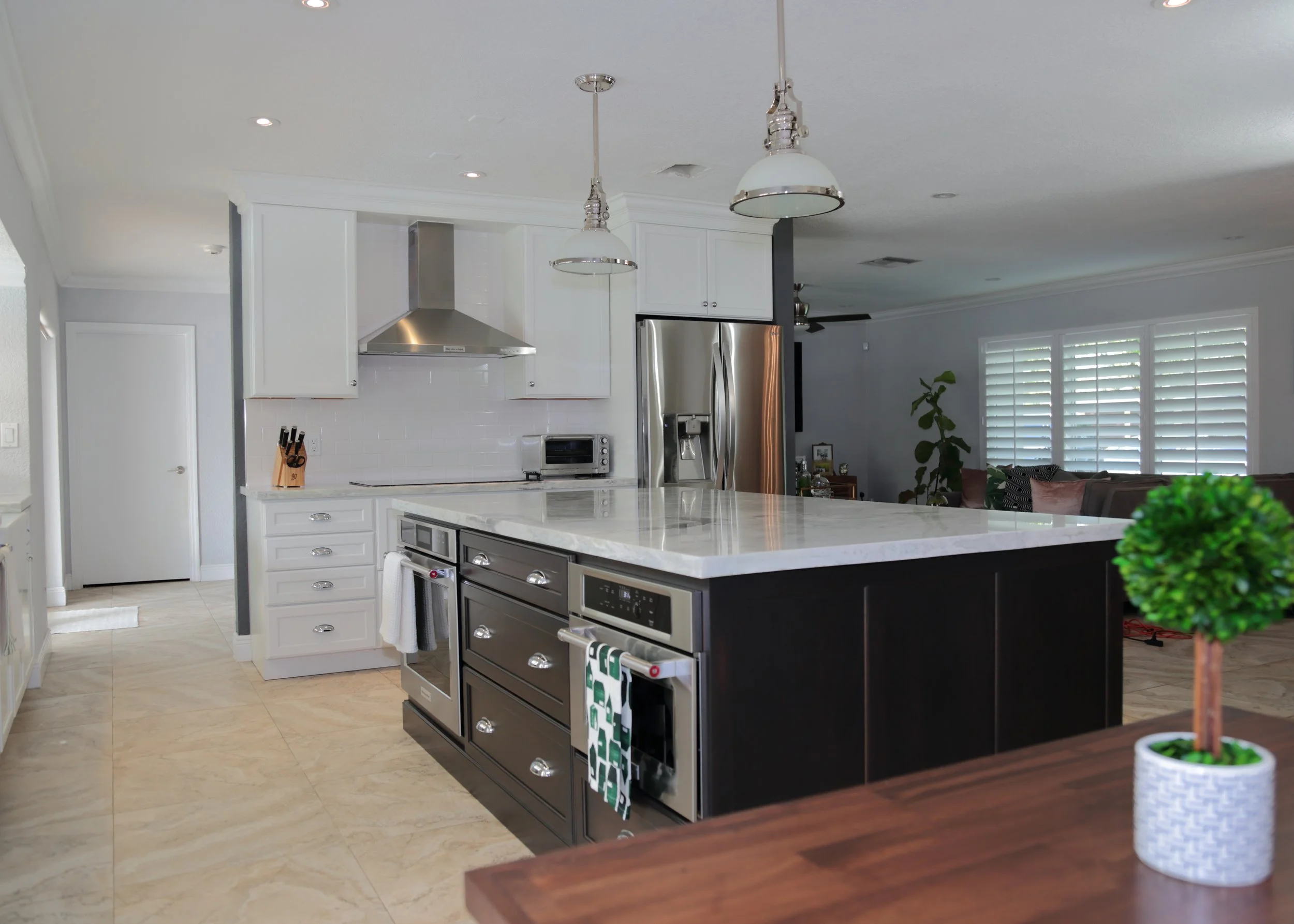 Lake Park kitchen with white perimeter cabinetry, a dark wood island, stainless appliances, and light countertops