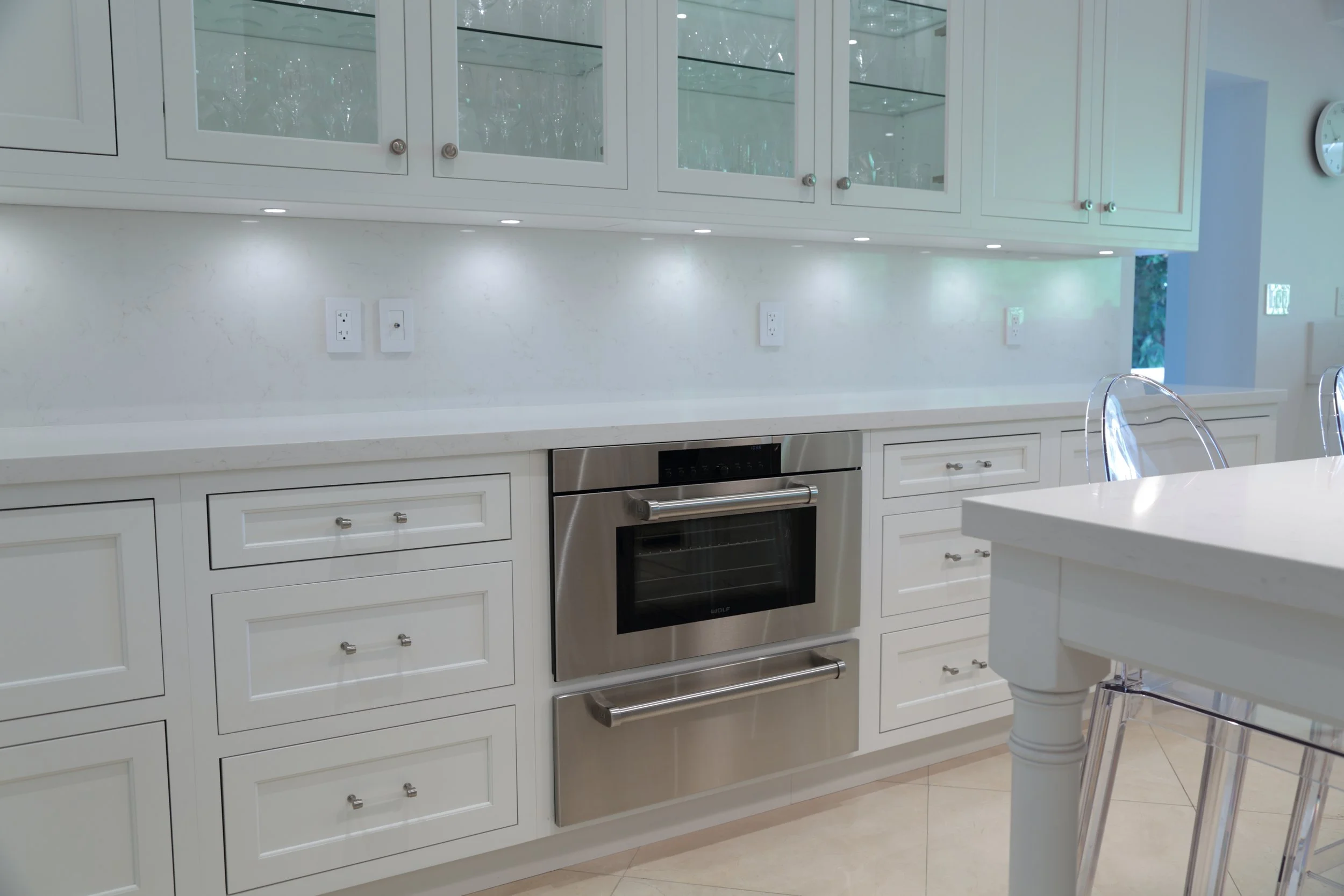 White kitchen drawer banks with a built-in microwave beneath the countertop