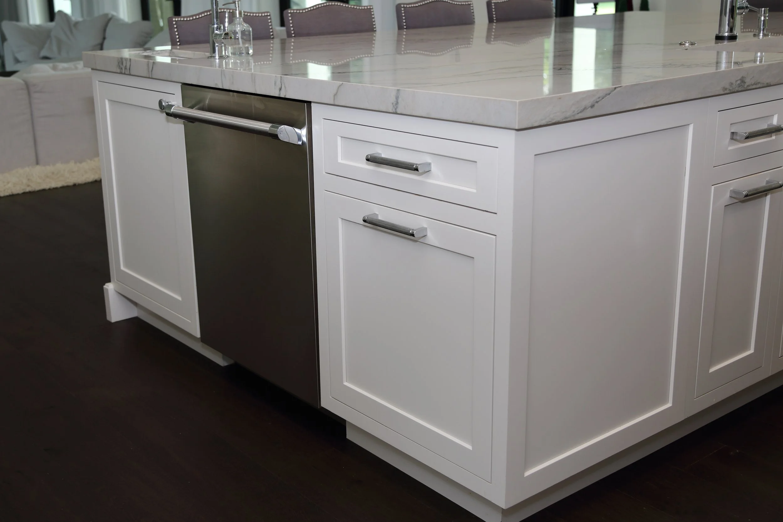 Dishwasher fitted beside white island cabinet drawers