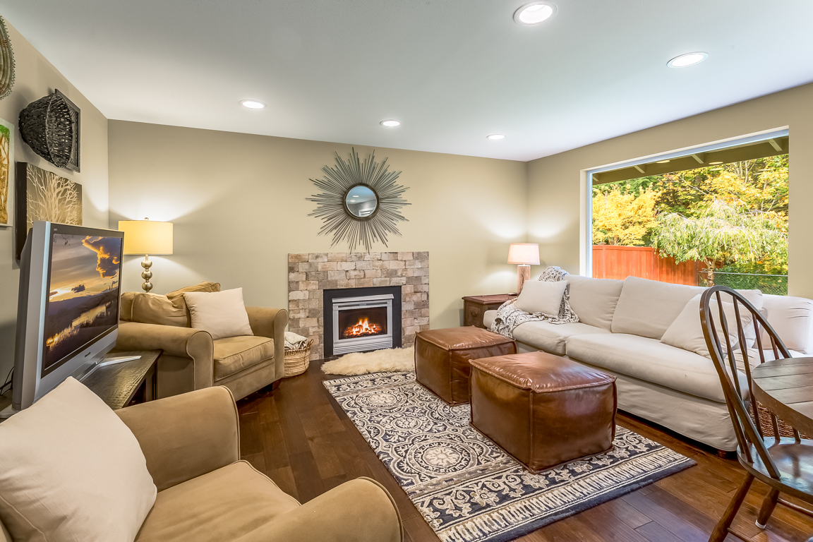 In the family room, we re-tiled the fireplace surround and continued the flooring throughout. We added tons of can lighting to this home, making to light and bright. 