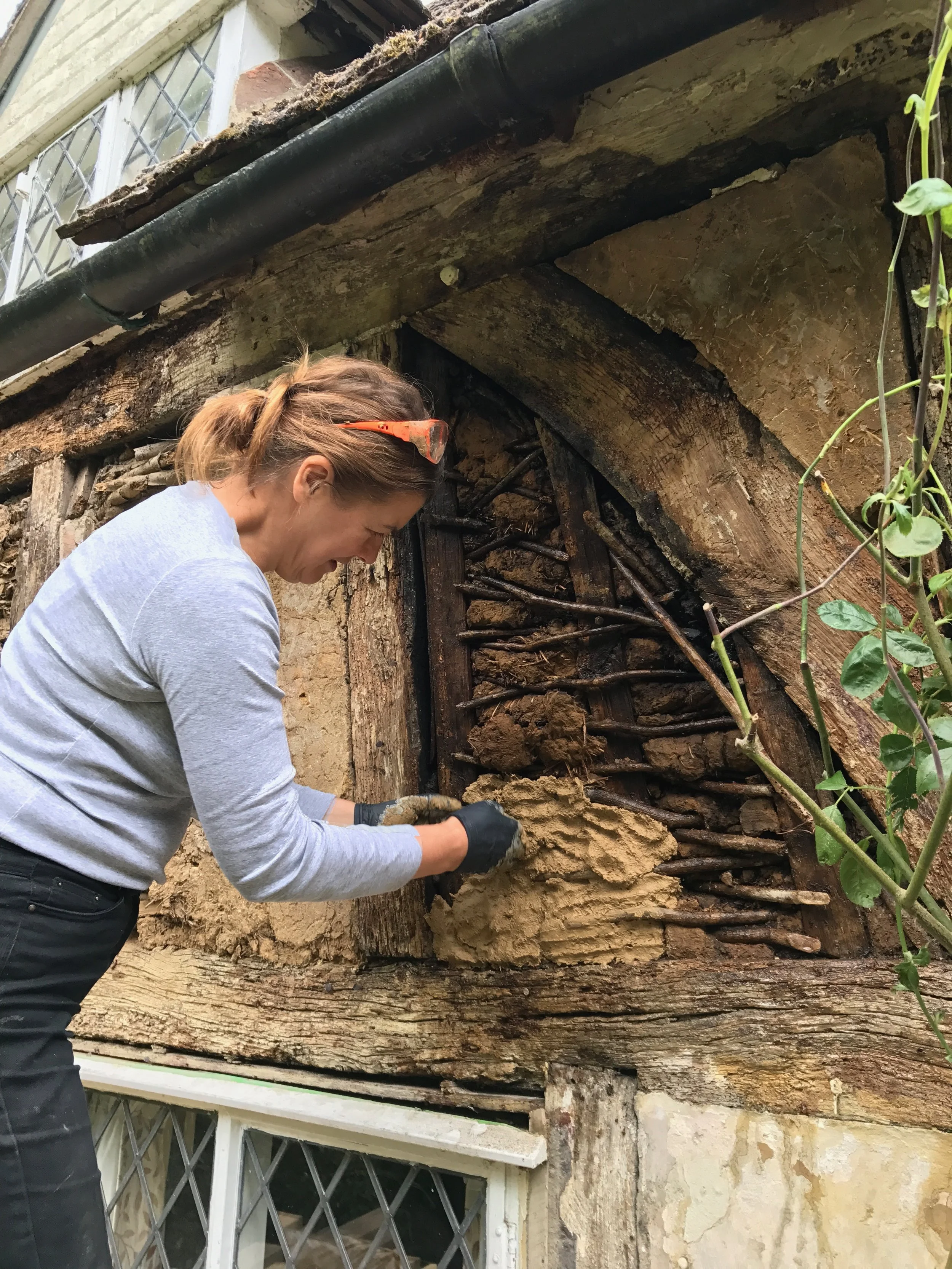 In this image 600 year old wattle and daub is being repaired, incorporating much of the original wattle and daub.