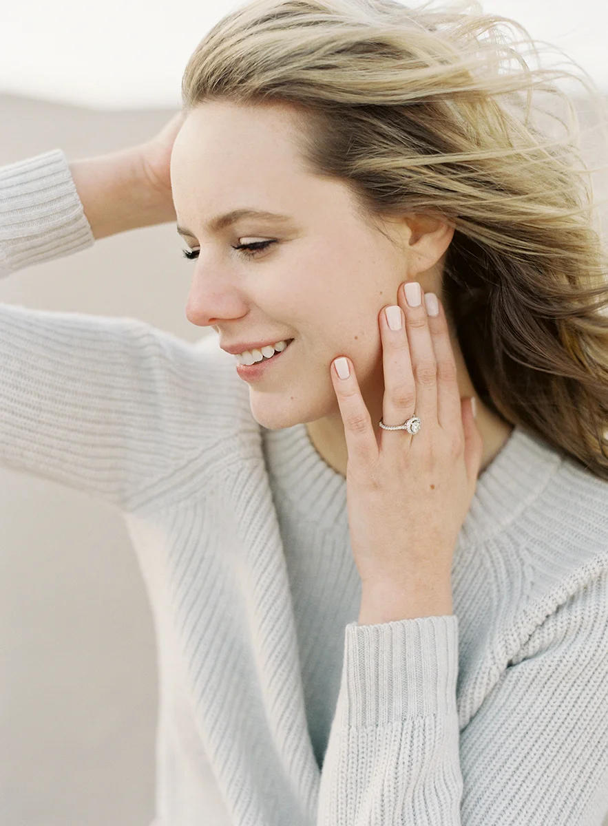 wind swept hair with engagement ring on film