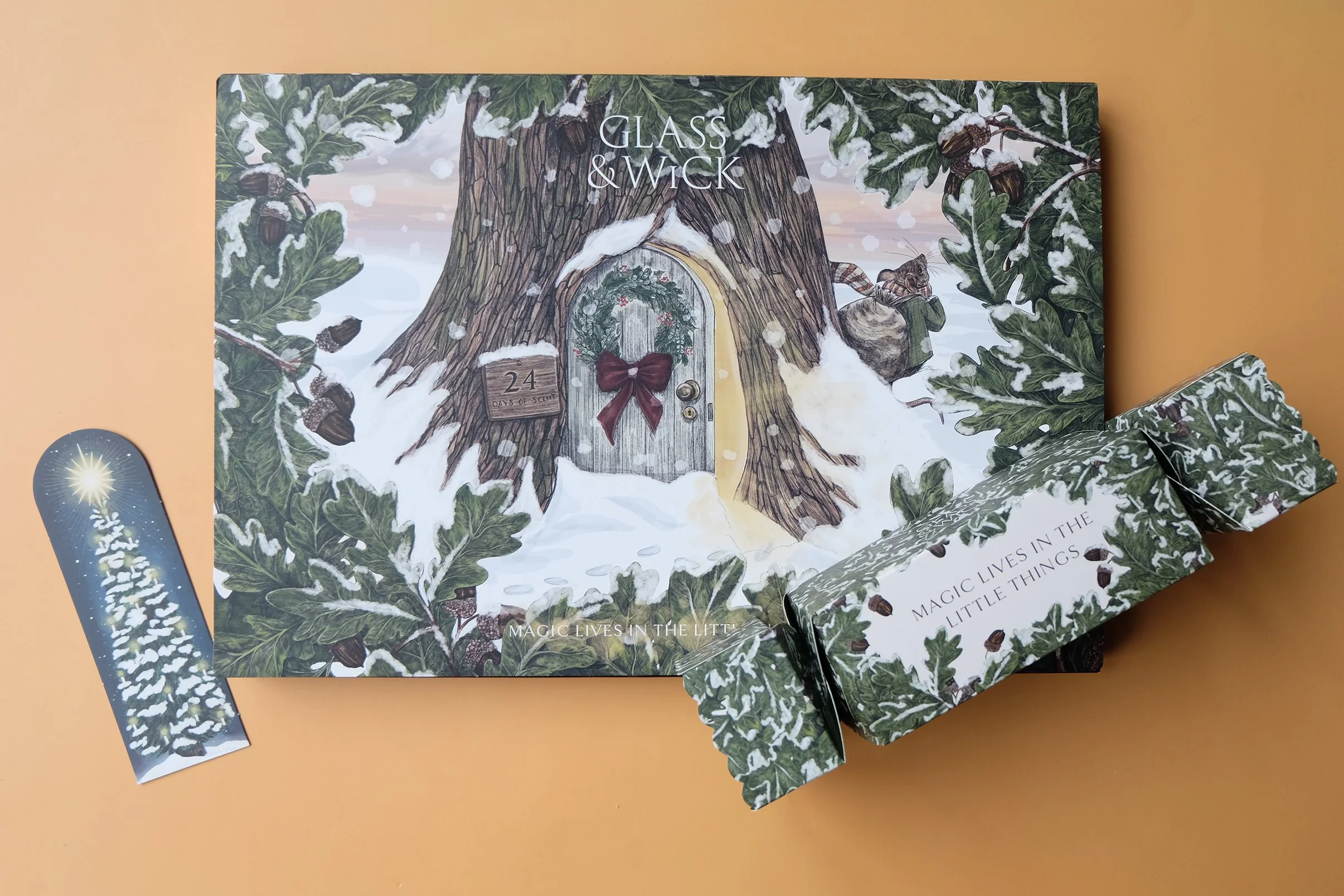 Glass & Wick Advent Calender 2025 along with an illustrated bookmark and Christmas cracker gift box as part of the product range.