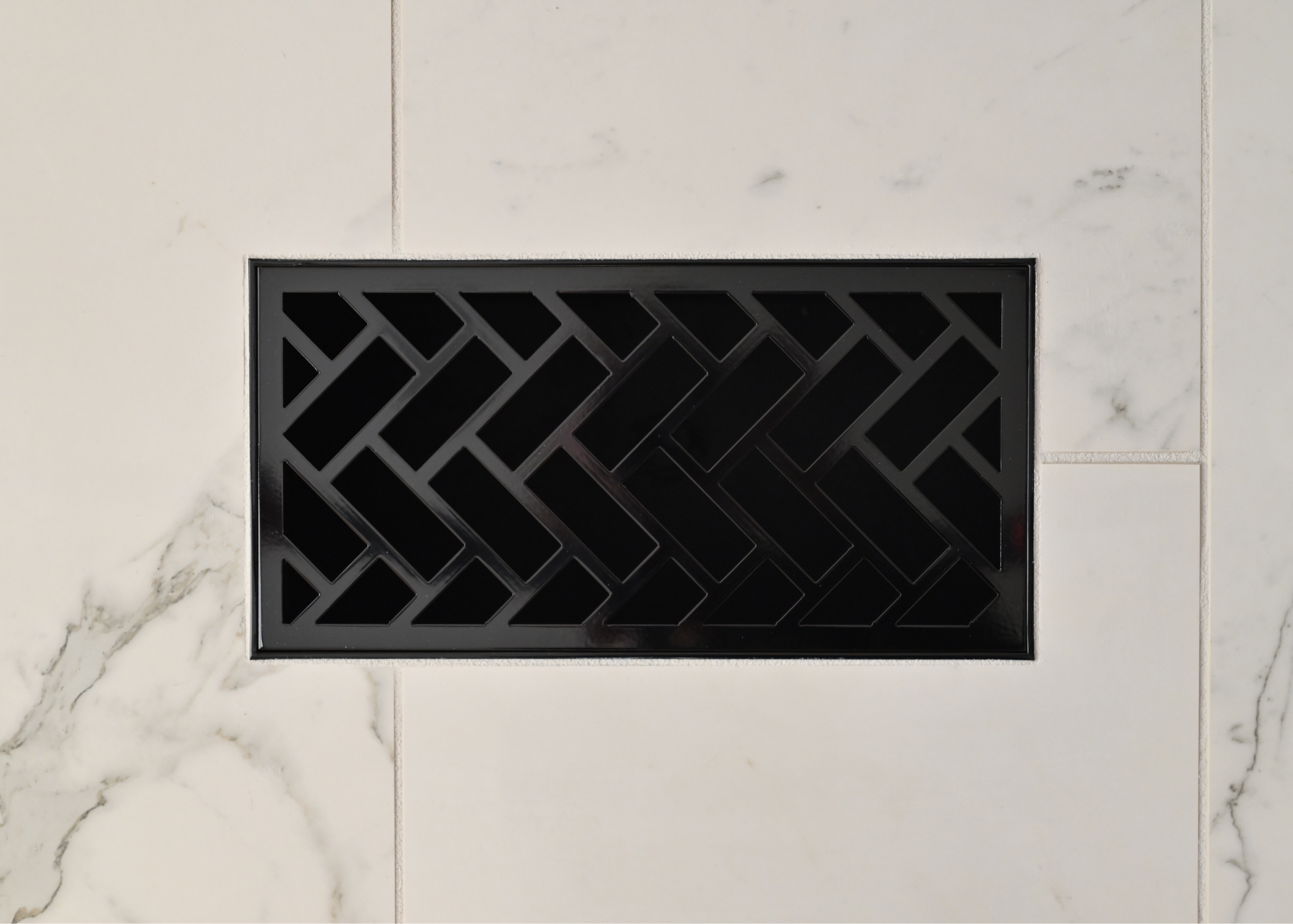 Here is a great example of our decorative metal grill installed flush into tile. You can see the gloss black finish reflecting the light around it giving the steel register and sleek finish. 