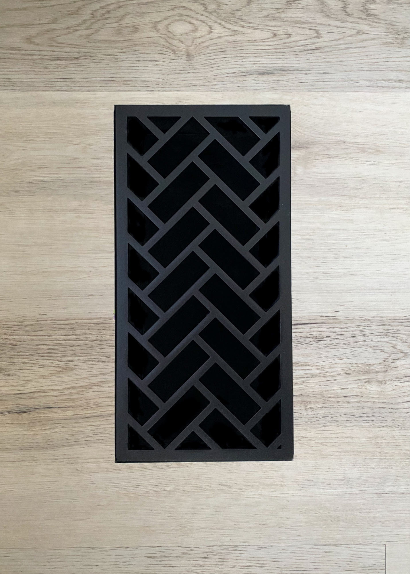 Metal grill that is flush mounted into LVP flooring. With high airflow and a beautiful herringbone design. 