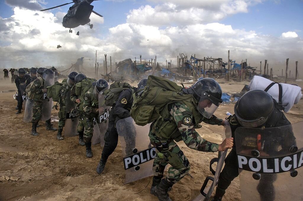 Peruvian police await transport helicopters at the end of an interdiction operation in the illegal gold mining area of La Pampa, in Madre de Dios, on July 14, 2015. Source: Getty/Ernesto Benavides