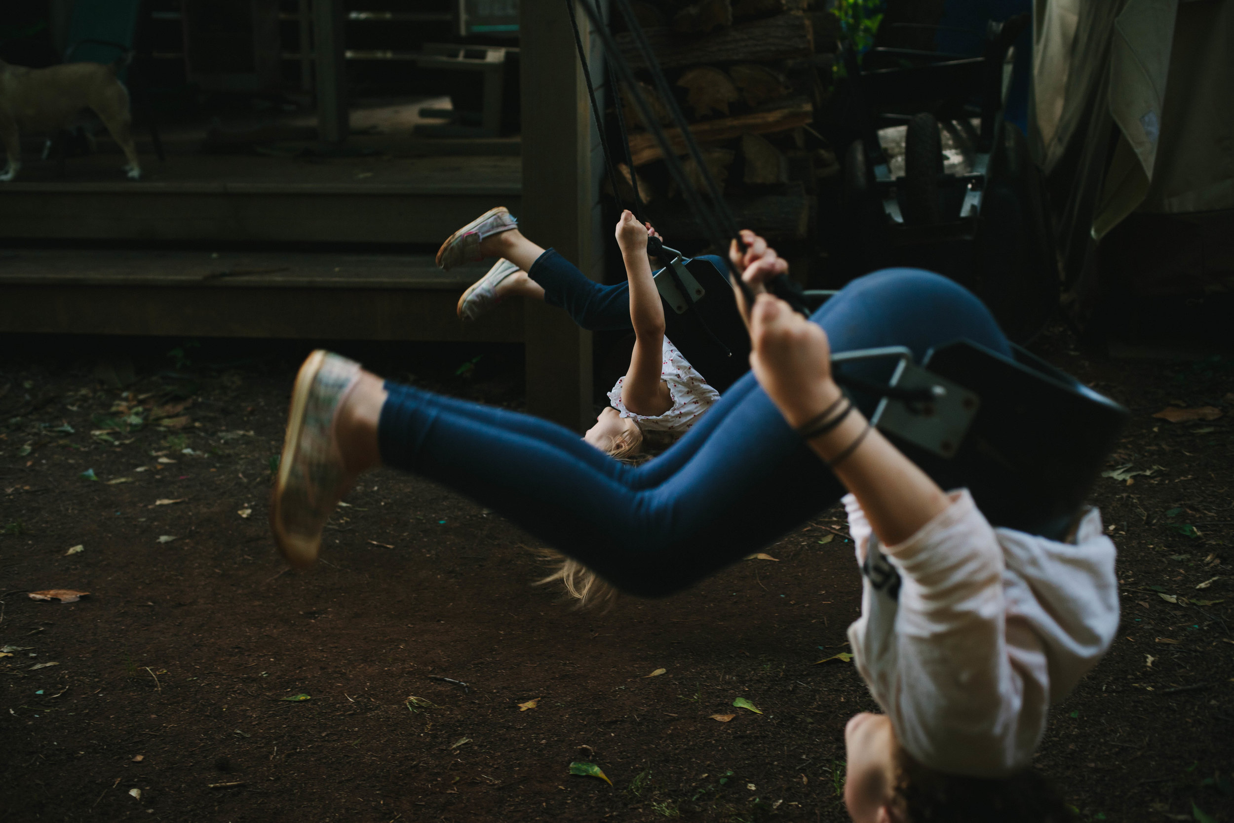 two girls flipping on a swing at the same time from portrait of play documentary photography session in atlanta