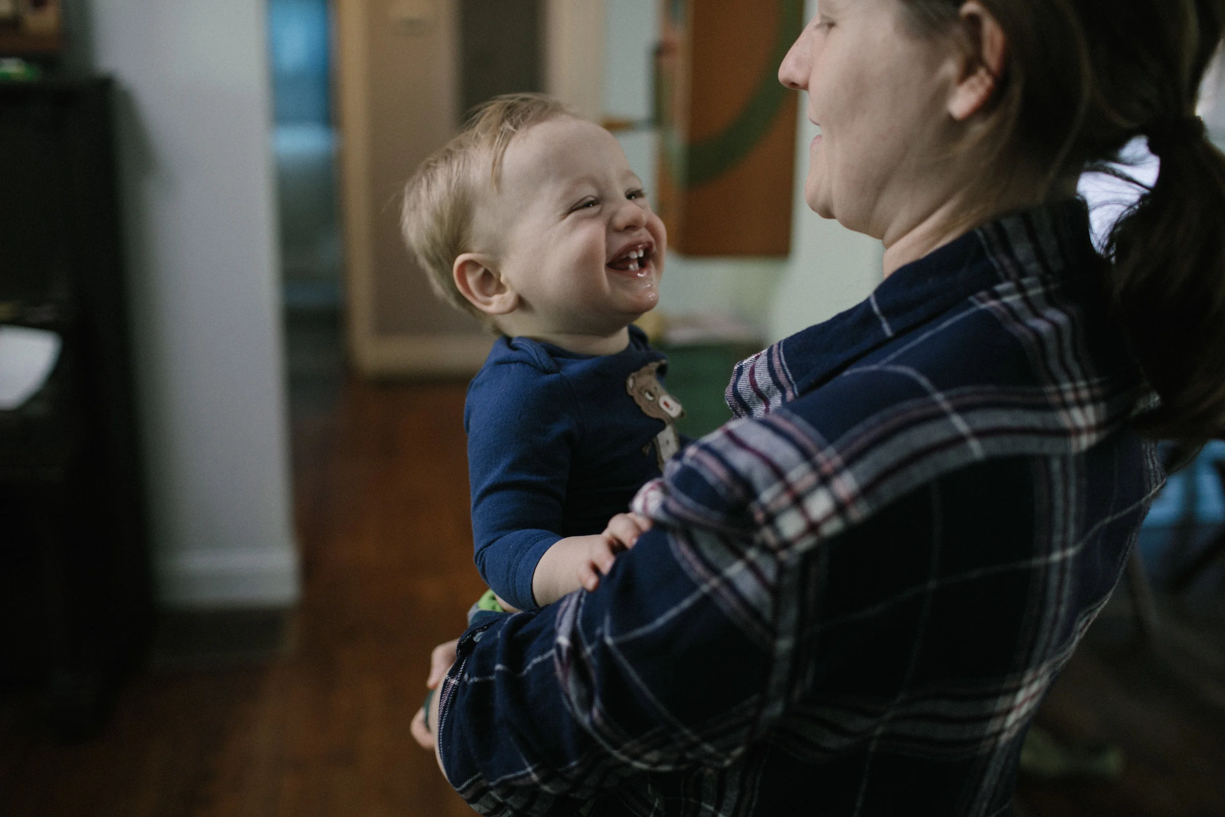 son smiles at mother who is holding him