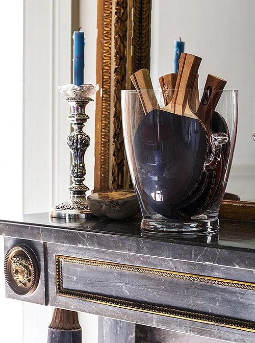 Illustrating her casual way with traditional pieces, Sara stores the ping-pong paddles in an ice bucket alongside an antique silver candlestick.