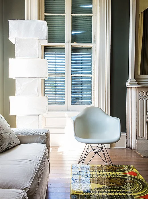 In the bedroom seating area, the gleaming white Eames chair and Noguchi lamp echo the bed’s pale geometry and modern feel. A Fornasetti table adds a bit of color.