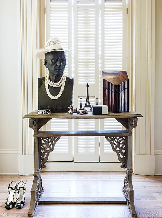 In a bedroom antechamber, a table by Thomas O’Brien displays a vintage knife holder (now used to store letters) and, adding a little levity, a vintage bust decked out in a hat and pearls. “I just have a thing for busts. When you’re lonely it’s like having some friends in the house.”